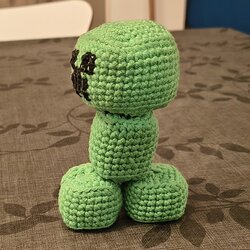 Le Creeper au crochet terminé vu de profil, avec sa tête cubique, son corps rectangulaire et ses pieds en blocs